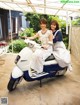 A couple of women sitting on top of a motor scooter.