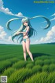 A girl in a bikini standing in a field of green grass.