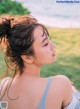 A woman with her hair in a messy bun looking away from the camera.