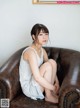 A woman sitting on top of a brown leather chair.